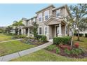 Two-story townhome with neutral siding, landscaped yard, and covered porch at 9457 Randal Park Blvd, Orlando, FL 32832