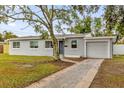 Newly renovated single-story home with gray exterior, landscaping, and driveway at 107 Japonica Dr, Orlando, FL 32807