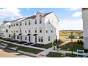 Modern townhome community with white townhouses and a lake view at 15100 Grove Lake Dr, Winter Garden, FL 34787