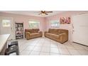 Cozy living room with brown sofas and tile floors at 20 Barry Ave, Mascotte, FL 34753