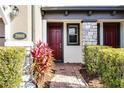 Townhome entry with red door, stone accents, and manicured landscaping at 2909 Econ Landing Blvd, Orlando, FL 32825