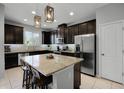 Modern kitchen with dark cabinetry, granite countertops, and stainless steel appliances at 2909 Econ Landing Blvd, Orlando, FL 32825