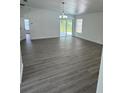 Spacious living room with grey wood-look floors and access to backyard at 620 Heraldo Ct, Kissimmee, FL 34758