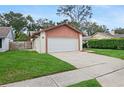 Attached garage with white door, green lawn and trimmed hedges at 654 Boniview Ln, Altamonte Springs, FL 32714
