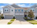 Two-story townhome with gray siding, two-car garage, and landscaping at 9218 Shepton St, Orlando, FL 32825