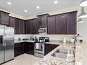 Spacious kitchen with dark wood cabinets, granite countertops, and stainless steel appliances at 9218 Shepton St, Orlando, FL 32825