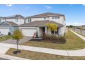 Two-story house with gray and white siding, a three-car garage, and a landscaped yard at 985 Savannah Palms Blvd, Orlando, FL 32828