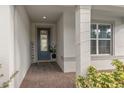 Inviting front entry with a blue door, welcome sign, and brick flooring at 985 Savannah Palms Blvd, Orlando, FL 32828