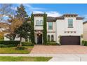 Two-story house with a white exterior, brown garage door, and a brick driveway at 16669 Varone Cove Ct, Winter Garden, FL 34787