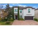 Two-story house with a white exterior, brown garage door, and a brick driveway at 16669 Varone Cove Ct, Winter Garden, FL 34787