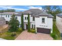 Two-story house with a white exterior, brown garage door, and a brick driveway at 16669 Varone Cove Ct, Winter Garden, FL 34787