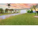 Inviting single-story home featuring lush green landscaping and a convenient attached two-car garage at 218 S Venetian Way, Port Orange, FL 32127