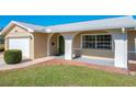 Green front door and brick porch of a tan brick home at 2207 Winter Woods Blvd, Winter Park, FL 32792