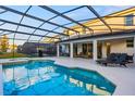 Screened-in pool area featuring a swimming pool, spa, and outdoor seating area with comfortable lounge furniture at 2628 Calistoga Ave, Kissimmee, FL 34741