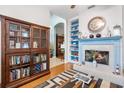 Cozy living room features a fireplace, built-in shelving, and hardwood floors at 3566 Tropical Seas Loop, Tavares, FL 32778