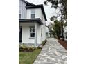 Paved driveway leading to two-story house with gray and white exterior at 62 W Esther W St, Orlando, FL 32806