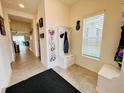 Bright entryway with storage bench, coat hooks, and a view into the living area at 6976 Church Lake St, Groveland, FL 34736