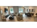 Open concept living and dining area with modern furniture and a large TV at 7770 Sandy Ridge Dr # 126, Reunion, FL 34747