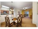 Bright dining area with a glass-top table and four chairs, adjacent to kitchen at 8101 Resort Village Dr # 31308, Orlando, FL 32821