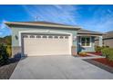 Light blue house with a white garage door and landscaped front yard at 8134 Sw 78Th Terrace Rd, Ocala, FL 34476