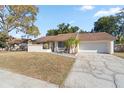 Single-story house with brown roof, red door, and landscaped front yard at 1163 Queen Elaine Dr, Casselberry, FL 32707