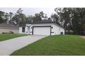 Well-manicured lawn and driveway leading up to the two-car garage of a charming home at 13215 Sw 41St Ct, Ocala, FL 34473