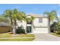 Two-story house with a green door, attached garage, and palm trees at 1633 Corner Meadow Cir, Orlando, FL 32820