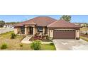 House exterior showcasing a brown roof, light beige siding, and a brown garage door at 1719 North W Blvd, Davenport, FL 33837
