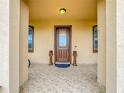 Charming front porch with decorative columns, a tiled floor, and a beautiful wood door at 1719 North W Blvd, Davenport, FL 33837