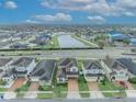 Aerial view of houses and a pond in a residential area at 2516 Nouveau Way, Kissimmee, FL 34741