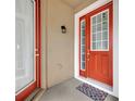 Red front door with glass panels and welcome mat at 2516 Nouveau Way, Kissimmee, FL 34741