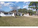 Front view of a white house with a green lawn at 2824 Oak Lea Dr, South Daytona, FL 32119