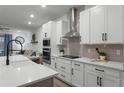 Modern kitchen with white cabinets, stainless steel appliances, and quartz countertops at 4558 Lions Gate Ave, Clermont, FL 34711