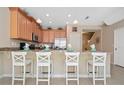 Island kitchen with light wood cabinets, granite countertops, and breakfast bar at 5120 Adelaide Dr, Kissimmee, FL 34746