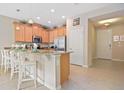 Modern kitchen with light wood cabinets, granite countertops, and stainless steel appliances at 5120 Adelaide Dr, Kissimmee, FL 34746