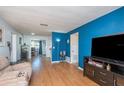 Bright living room with hardwood floors and a blue accent wall at 716 Katherine St, South Daytona, FL 32119