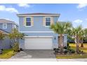 Two-story light blue house with a white garage door and landscaping at 7260 Oakmoss Loop, Davenport, FL 33837