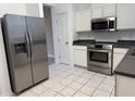 Modern kitchen features stainless steel appliances, white cabinets, and neutral tile flooring at 8634 Danforth Dr, Windermere, FL 34786