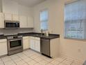 Bright kitchen with stainless appliances, white cabinetry, and neutral countertops at 8634 Danforth Dr, Windermere, FL 34786