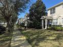 Neighborhood street view of townhouses with mature trees, sidewalks and landscaped front yards at 8634 Danforth Dr, Windermere, FL 34786