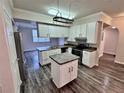 Modern kitchen with island, white cabinets, and stainless steel appliances at 911 N Orange Ave # 127, Orlando, FL 32801