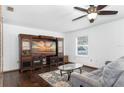Living room featuring a large TV, comfortable couch, and wood floors at 9877 7Th Ave, Orlando, FL 32824