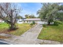 House with a long driveway and mature trees on a residential street at 1018 Bear Lake Rd, Apopka, FL 32703