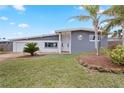 Newly remodeled home with grey exterior, palm trees, and landscaped yard at 1030 Bel Aire Dr, Daytona Beach, FL 32118