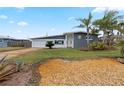 Newly remodeled home with grey exterior, palm trees, and landscaped yard at 1030 Bel Aire Dr, Daytona Beach, FL 32118