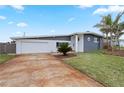 Newly remodeled home with grey exterior, palm trees, and landscaped yard at 1030 Bel Aire Dr, Daytona Beach, FL 32118