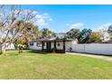 Ranch home with a covered porch, fenced yard, and mature trees at 117 Temple St, Deland, FL 32720