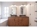 Bathroom with double vanity, wood cabinets, and arched mirrors at 14217 Sapphire Bay Cir, Orlando, FL 32828