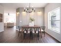 Modern dining room with wood floors, contemporary chandelier, and natural light from large windows at 14217 Sapphire Bay Cir, Orlando, FL 32828