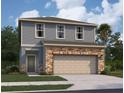 Two-story house with gray siding, stone accents, and a two-car garage at 1457 Dalkeith Cv, Sanford, FL 32771